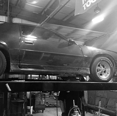 car on lift in service bay